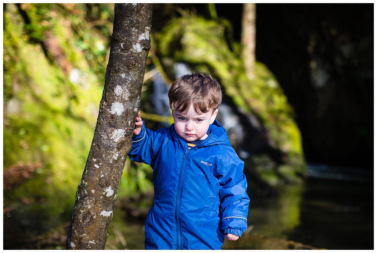 little boy watching the water and reflection catching the beautiful natural light at hitting his face