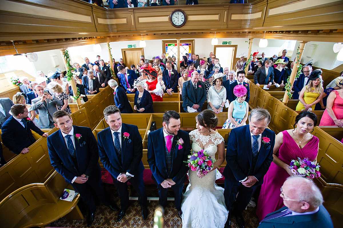 full photo of the church from the front of the chapel with the bride and groom looking cheeky at one another