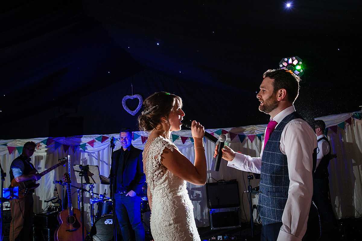 beautiful side lighting as the bride sings to the groom with the band in the background