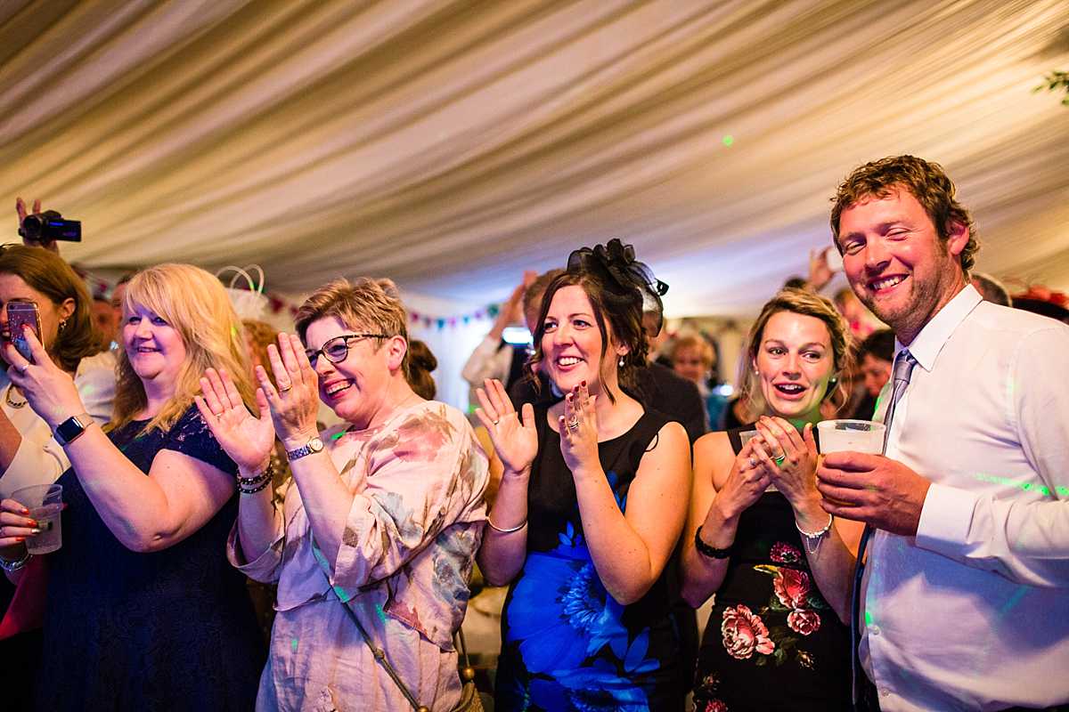 big applause to the bride and groom from their guests all standing and watching them do their first dance and song