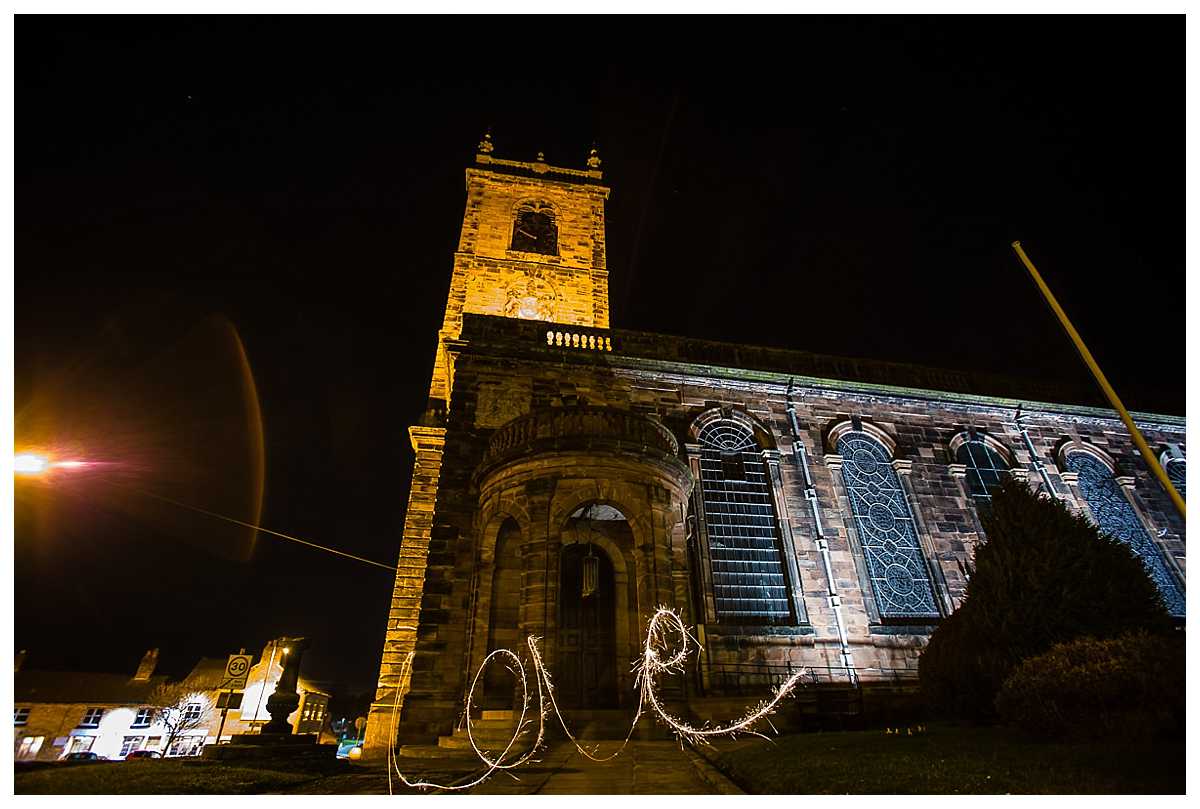 st alkmunds church lit up at night with love written in sparklers 