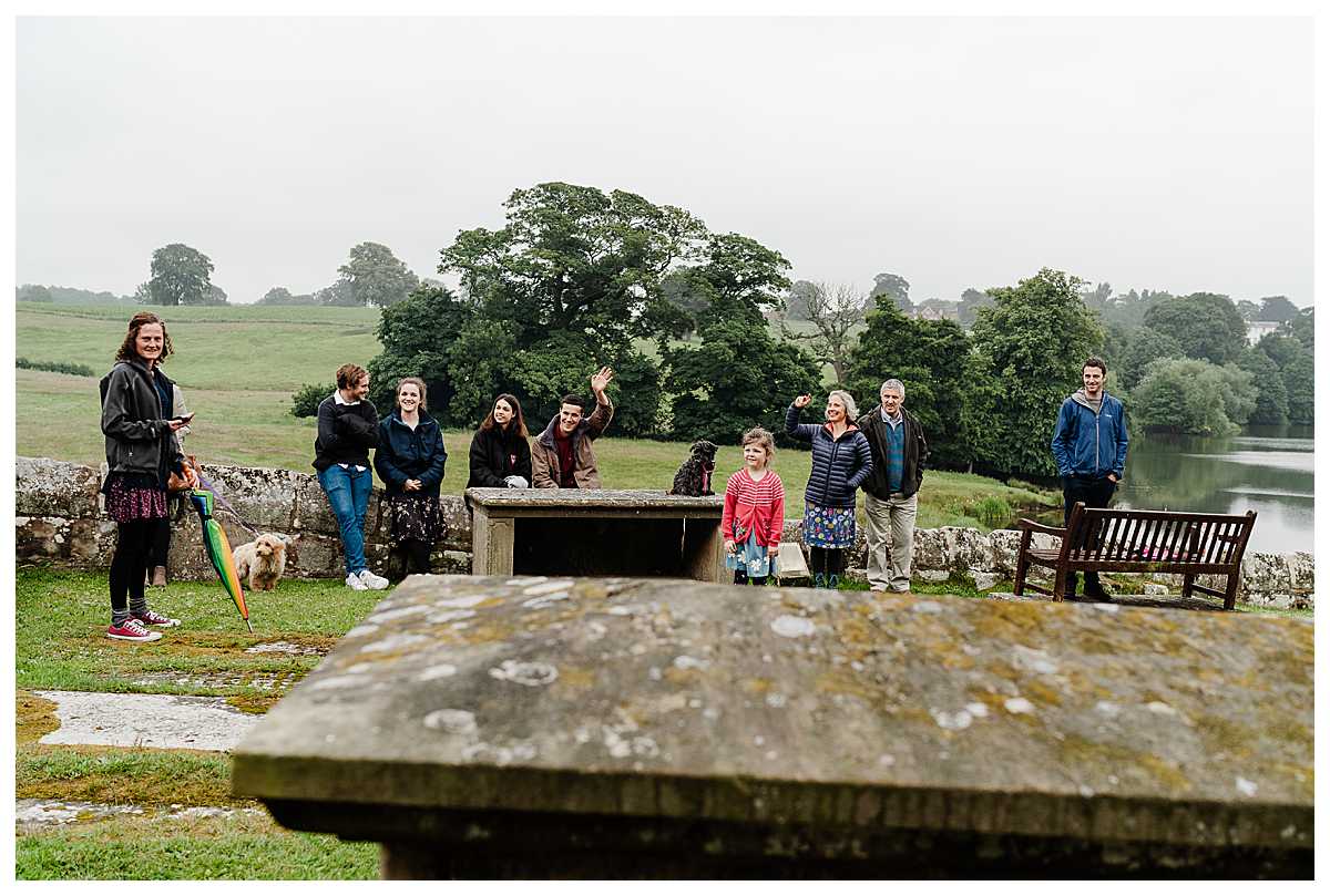 brides extended family waiting outside marbury church waiting for bride to arrive for shropshire wedding