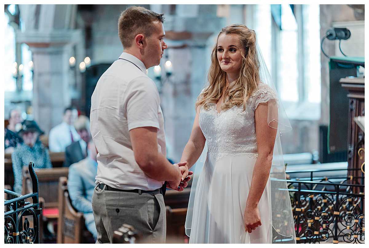bride and groom looking excited at one another as they say their vowels at marbury church whitchurch shropshire