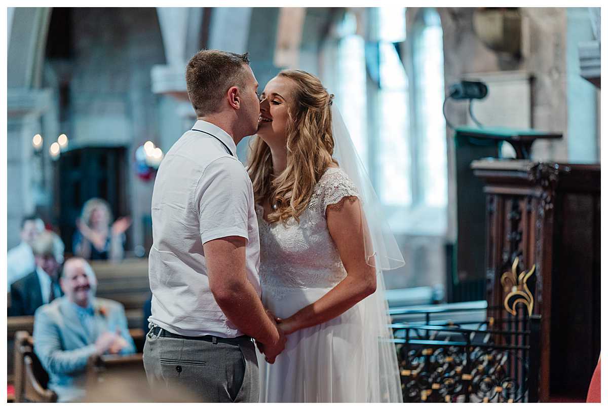 bride and groom first kiss as husband and wife, top of the aisle, marbury church, whitchurch, shropshire