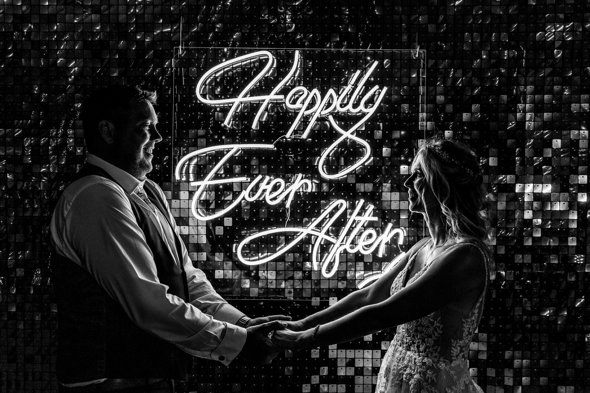 Cheshire DIY Tipi Wedding bride and groom standing infront of neon sign "happily ever after" looking so happy with each other at home tipi DIY wedding