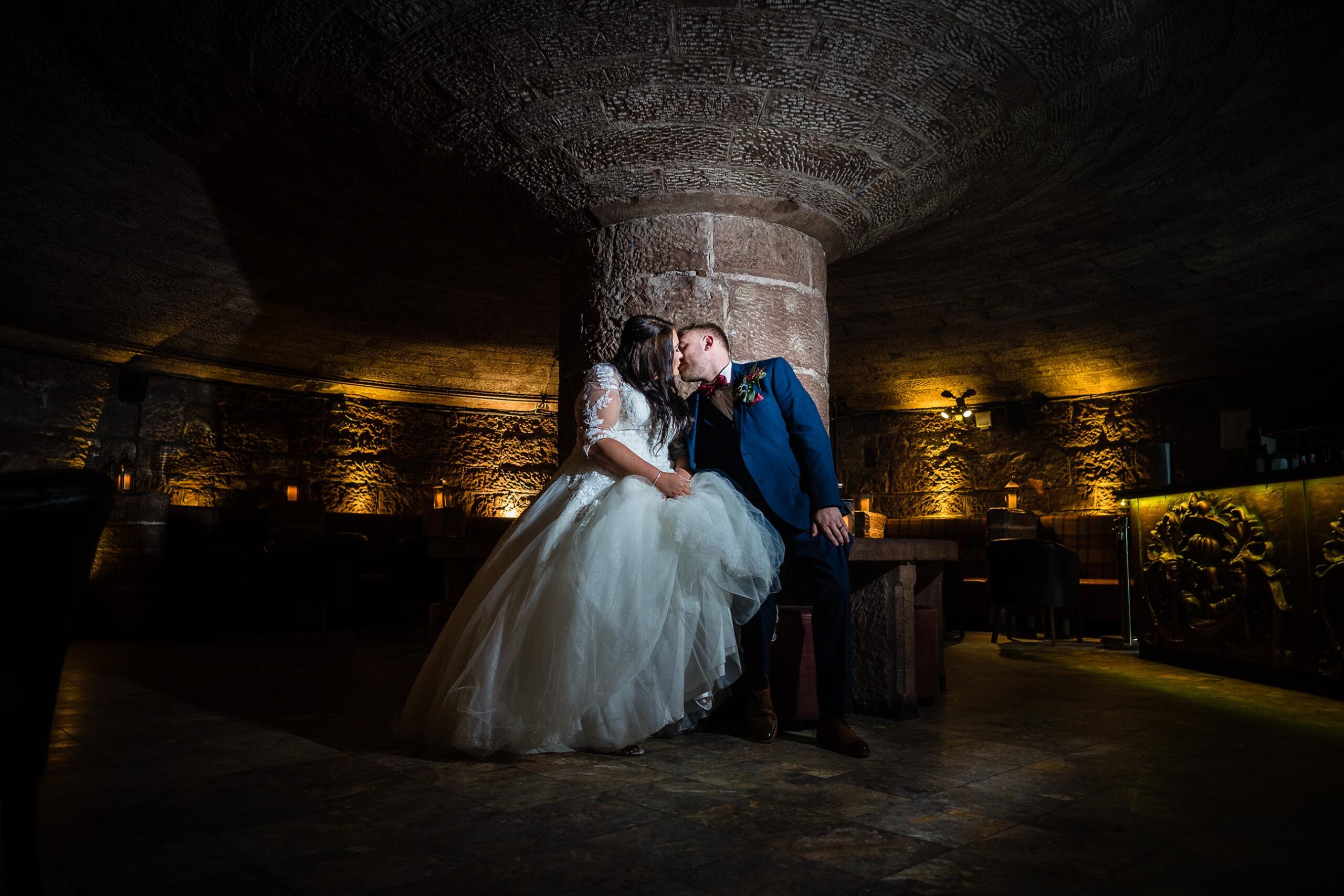 Bride and Groom having a kiss in the wine cellar Peckforton Castle