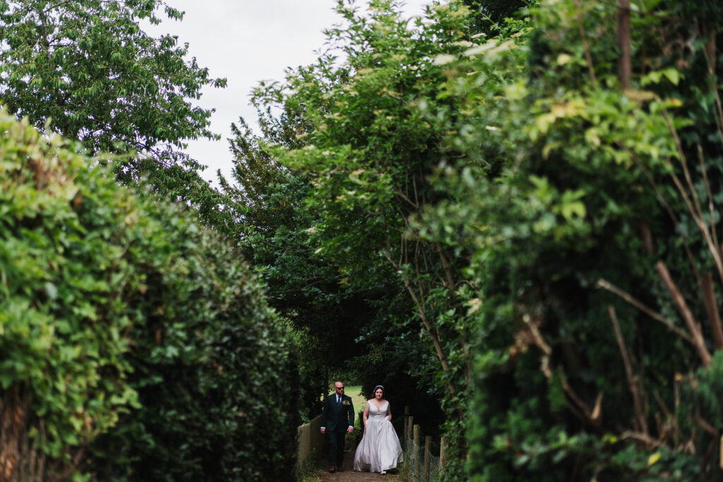 Bride and Groom walking to their wedding reception from Holy Trinity Church, Wistanstow to Wistanstow Village Hall