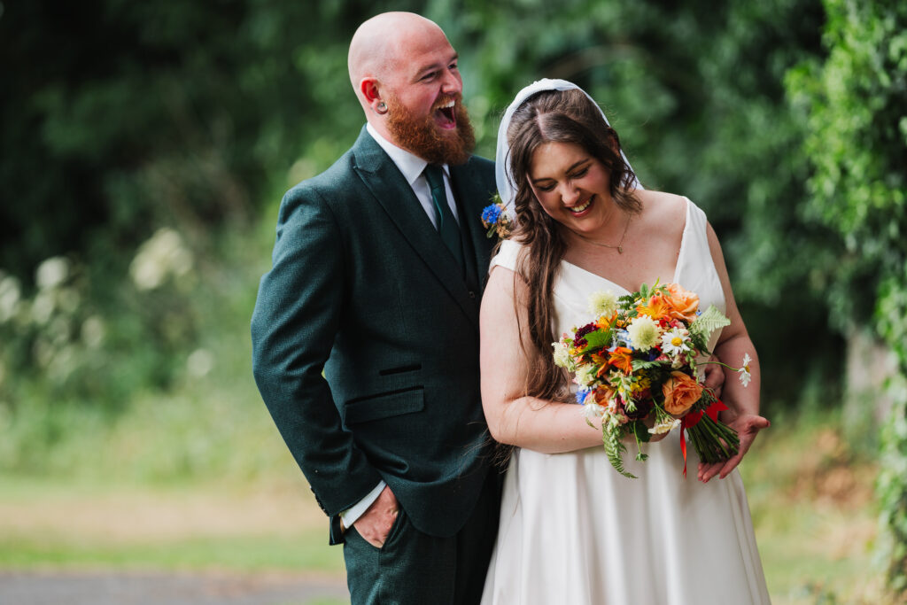 Bride and Groom giggling at Wistanstow Village Hall / Charlotte Giddings Photography