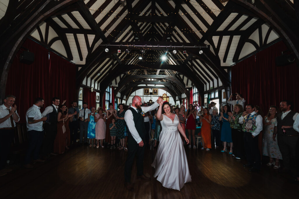 Bride and groom performing their first dance in front of friends and family at Wistanstow Village Hall