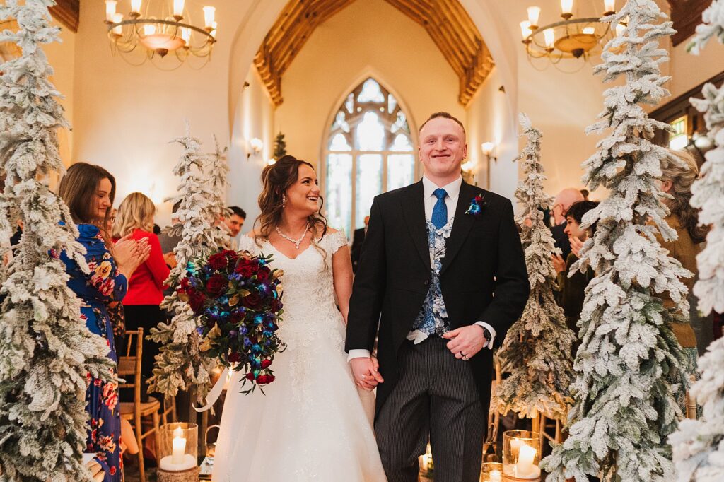 Bride and Groom walking down the aisle at their winter wonderland themed wedding after their wedding ceremony