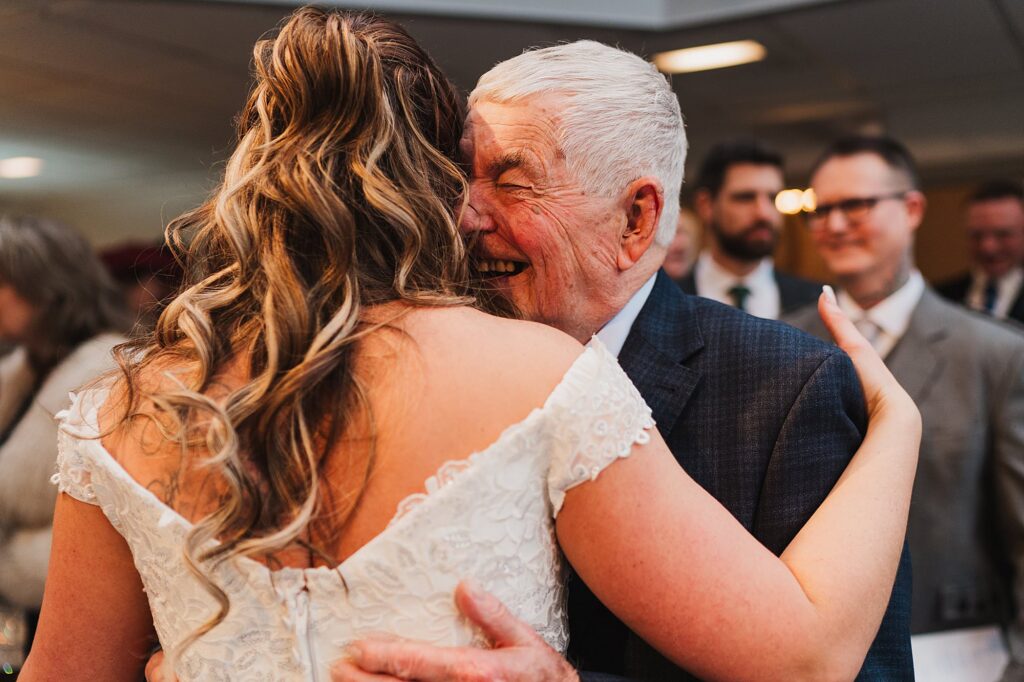 Grandad giggling and squeezing the bride after the ceremony at The Cloisters, Bolton Wedding Photography