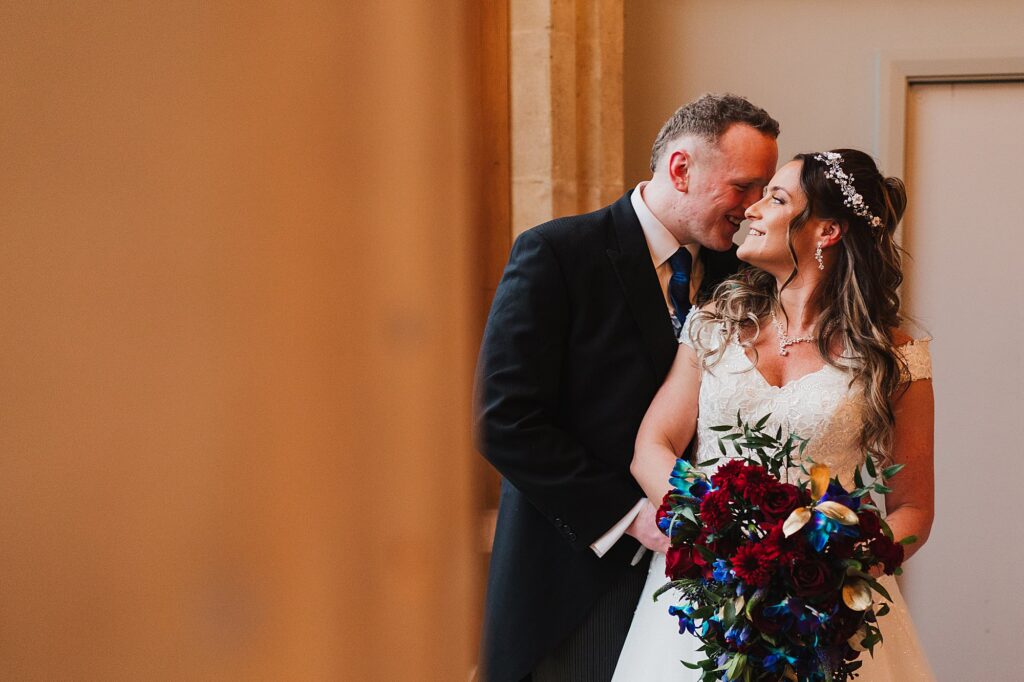 Bride and Groom having a moment together cuddling in the large windows at The Cloisters, Bolton