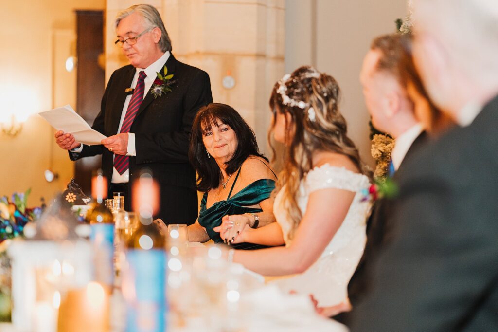 Bride's mother looking at her lovingly and holding the bride's hand during the Father of the Bride's speech // Charlotte Giddings Photography