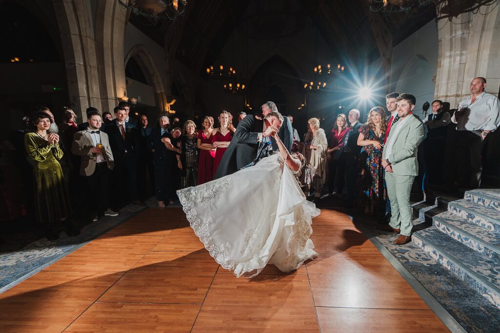 Bride and Groom performing the first dance, Groom dipping the bride catching the guests attention // Bolton Wedding Photographer