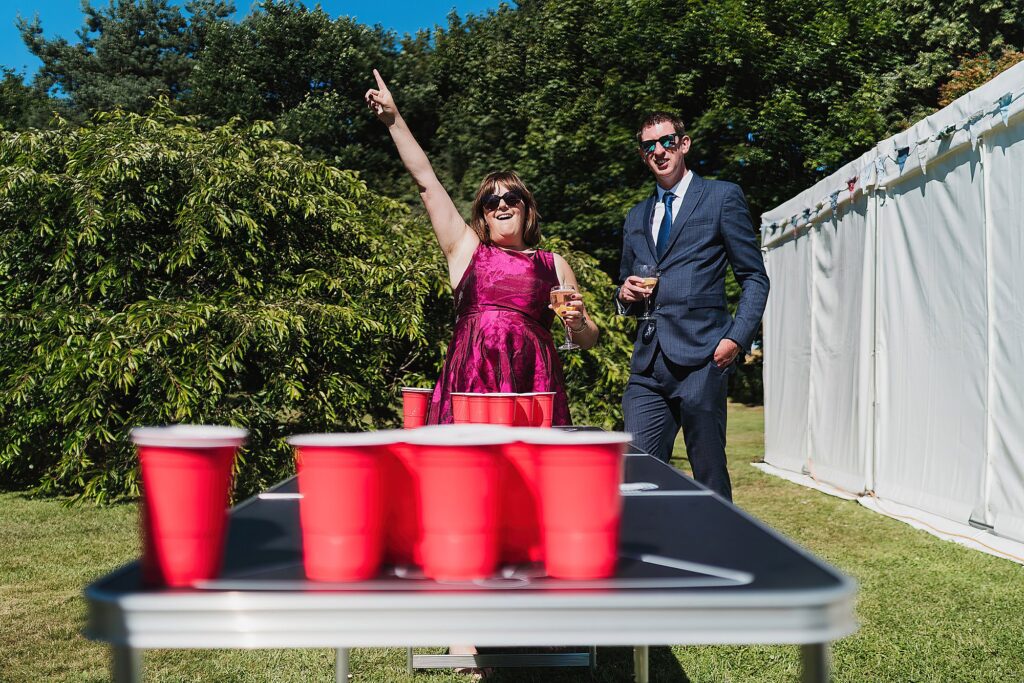 Guest elated as she has just won at a game of beer pong at a Dorothy Clive Wedding // Shropshire Wedding Venue