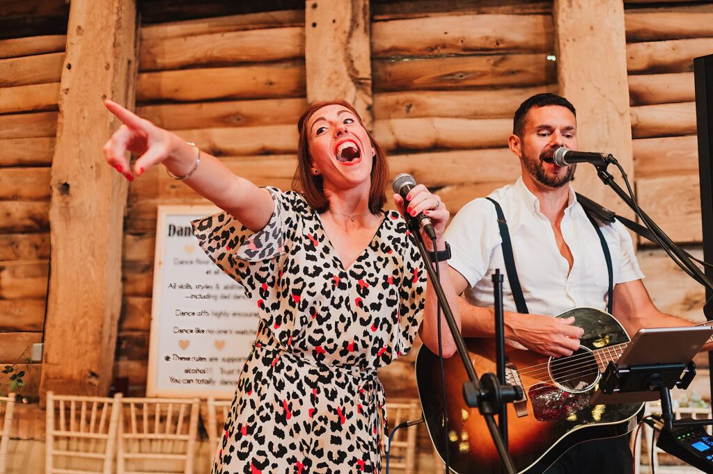 Wedding Guest taking control of the mic at Pimhill Barn Wedding Venue Shropshire pointing at the brides