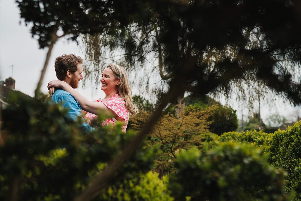 Bride and Groom chatting and giggling in the foilage in the garden // Shropshire Wedding Photographer