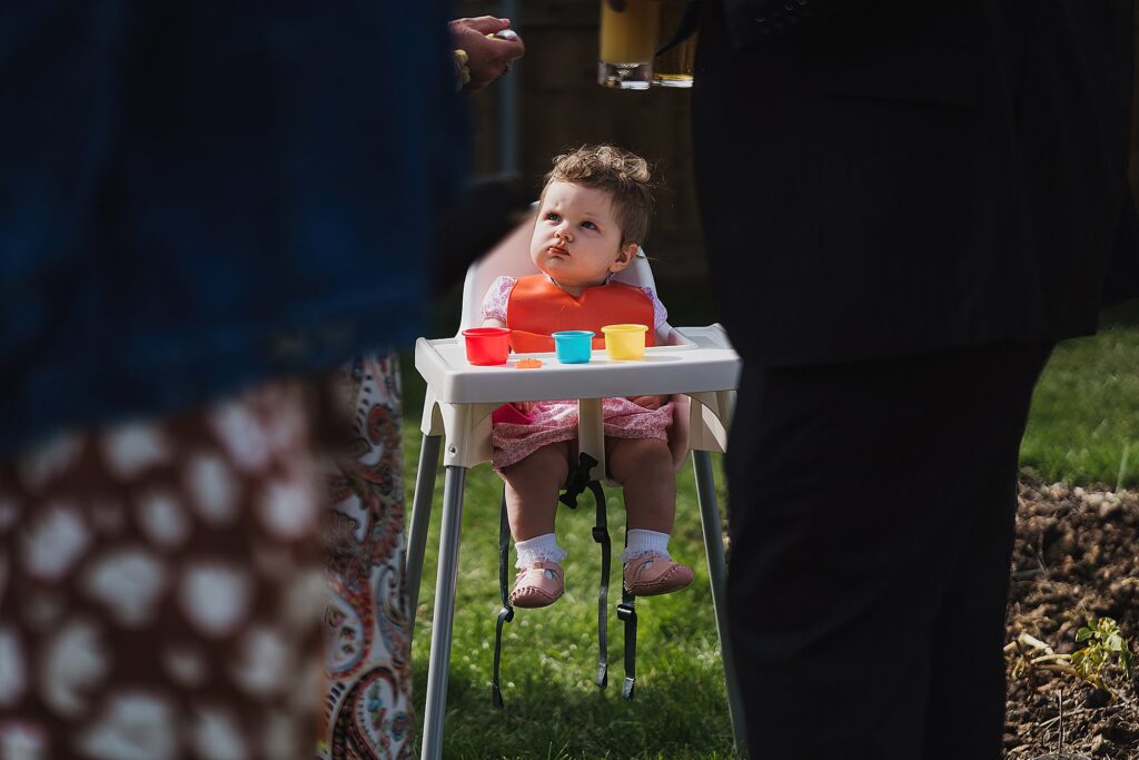 Baby looking serious at a wedding sat in a high chair // Welsh Wedding Photographer