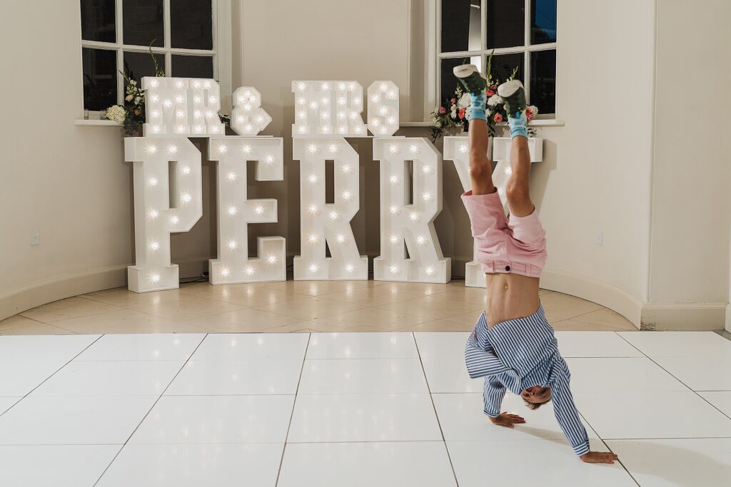 Young boy doing a handstand with large light up letters // Charlotte Giddings Photographer