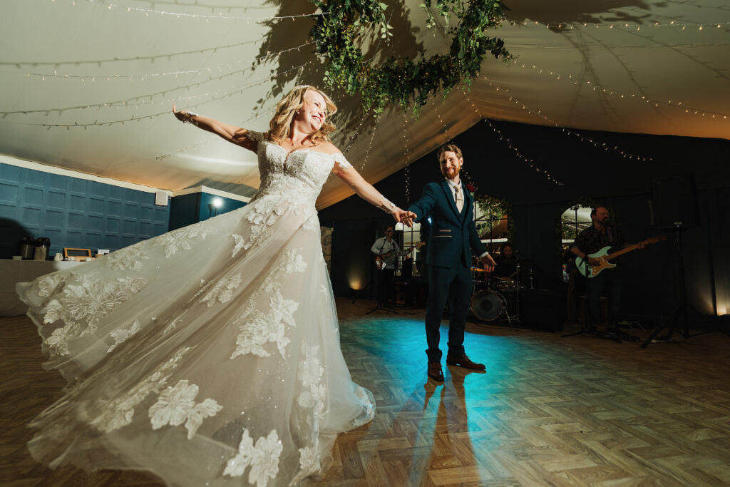 Bride and Groom performing their first dance at Combermere Abbey, swishing her wedding dress on a twirl // Dance floor action at Combermere Abbey