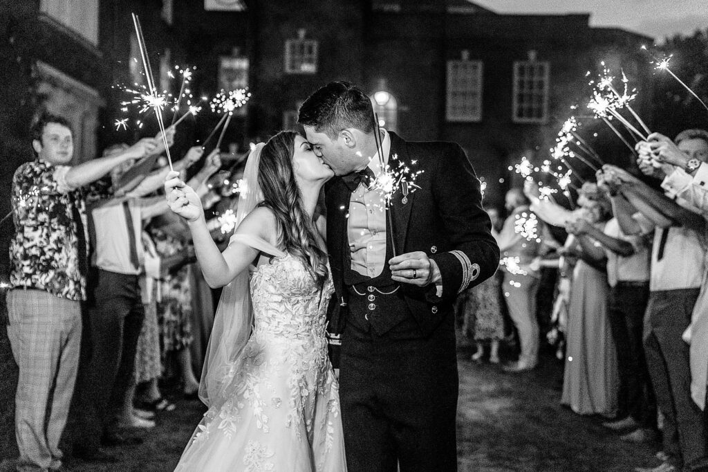 Bride and Groom have a kiss at Iscoyd Park holding sparklers on the sparkler exit // Iscoyd Wedding Photographer
