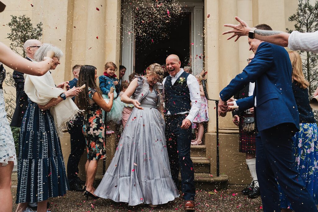 Bride and Groom covered in confetti surrounded by their guests at Elizabeth Gaskell House // Manchester Wedding Venue