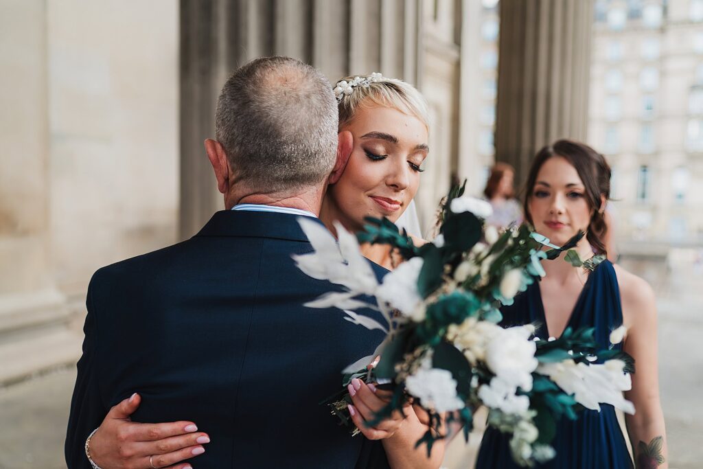 Bride cuddling and embracing with her Dad outside St. George's Hall before going to see the registrars//Liverpool Wedding Photographer
