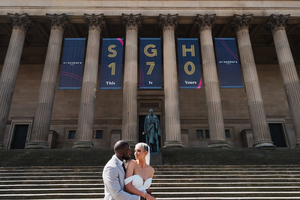 Bride and Groom looking cheekily back at each other with St. George's Hall in the background//Liverpool Wedding Photographer
