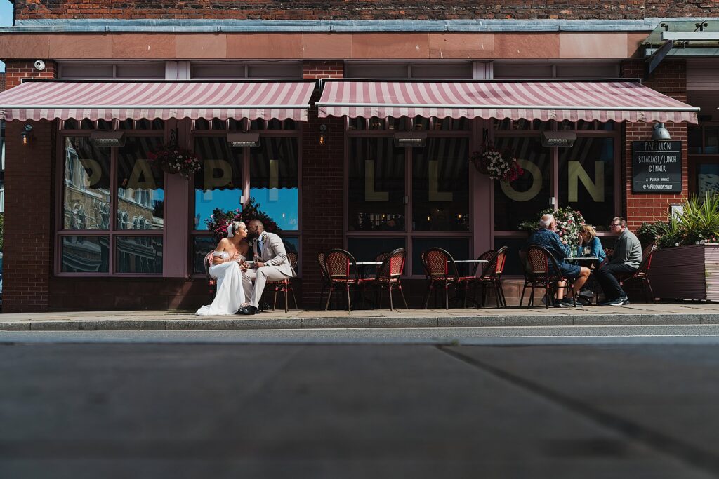 Bride and Groom sat romantically at a table outside a restaurant outside of Hope Street Hotel Liverpool//Charlotte Giddings Photography
