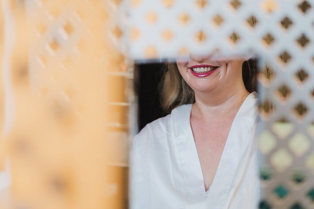 Reflection of the mirror with the bride smiling and freshly painted lips // Shropshire Wedding Photographer