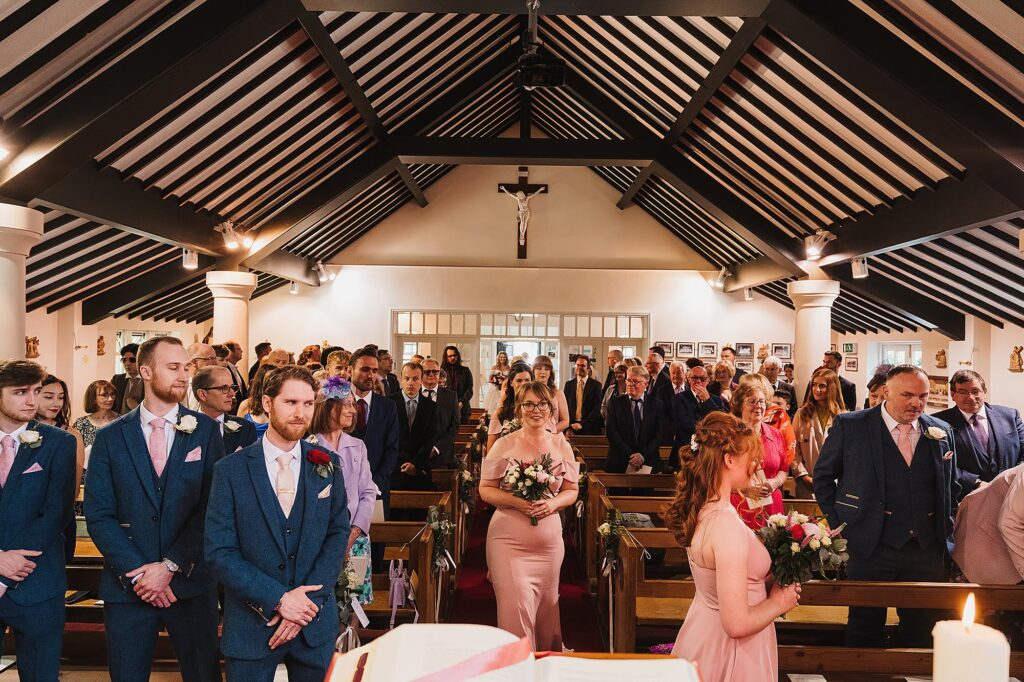 Bridesmaids walking down the aisle in the church at St. Anne's Nantwich // Charlotte Giddings Photography