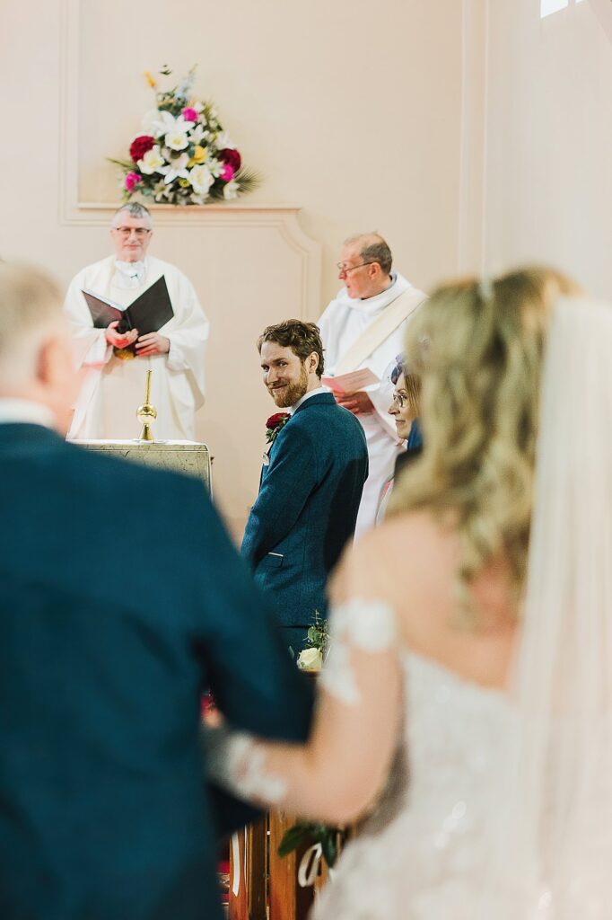 Groom looking back at the bride in church St Anne's Church Nantwich, Cheshire Wedding Photographer
