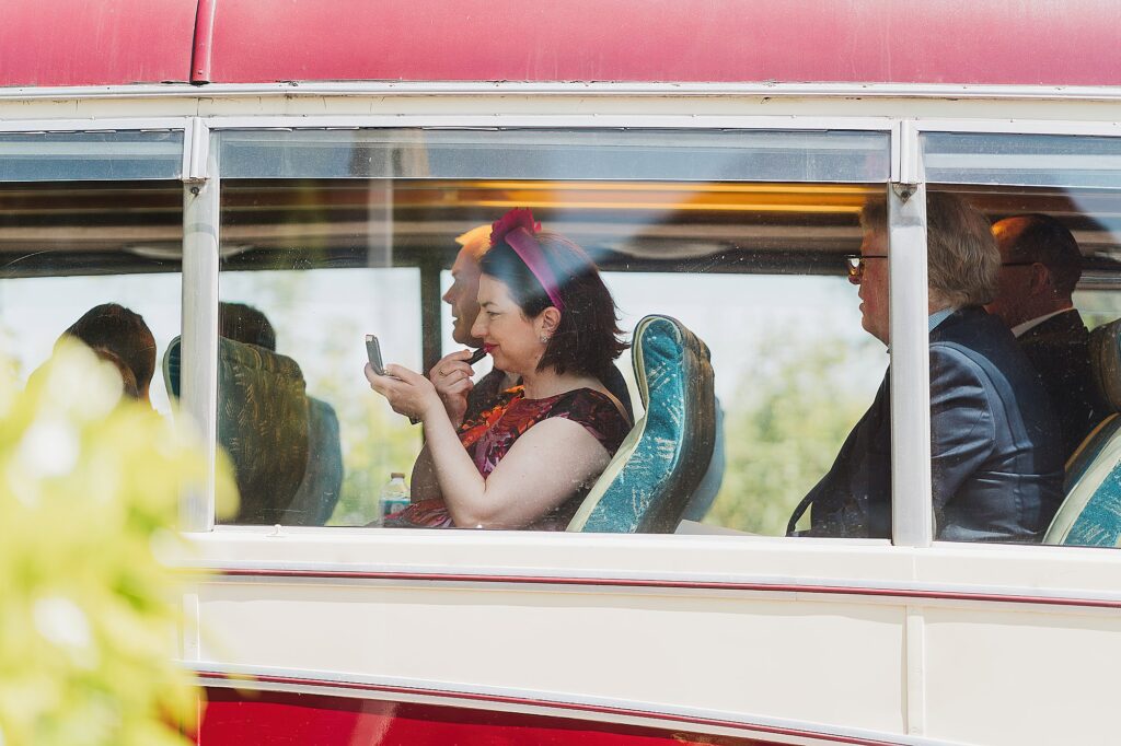 Wedding guest doing her make up on the bus before going to the wedding reception // Cheshire Wedding Photographer