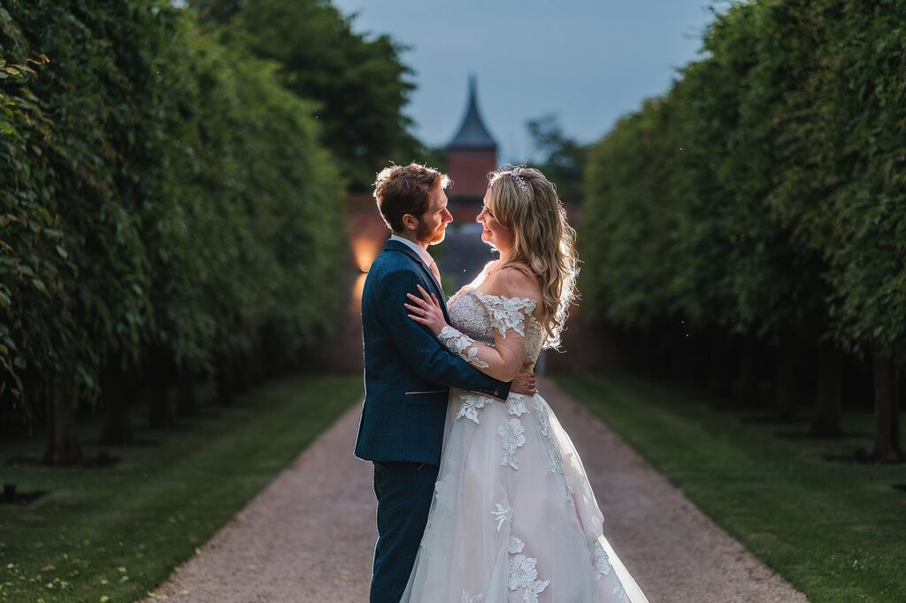 Romantic portrait of Bride and Groom in the tree lined walked way at Combermere Abbey // Charlotte Giddings Photography