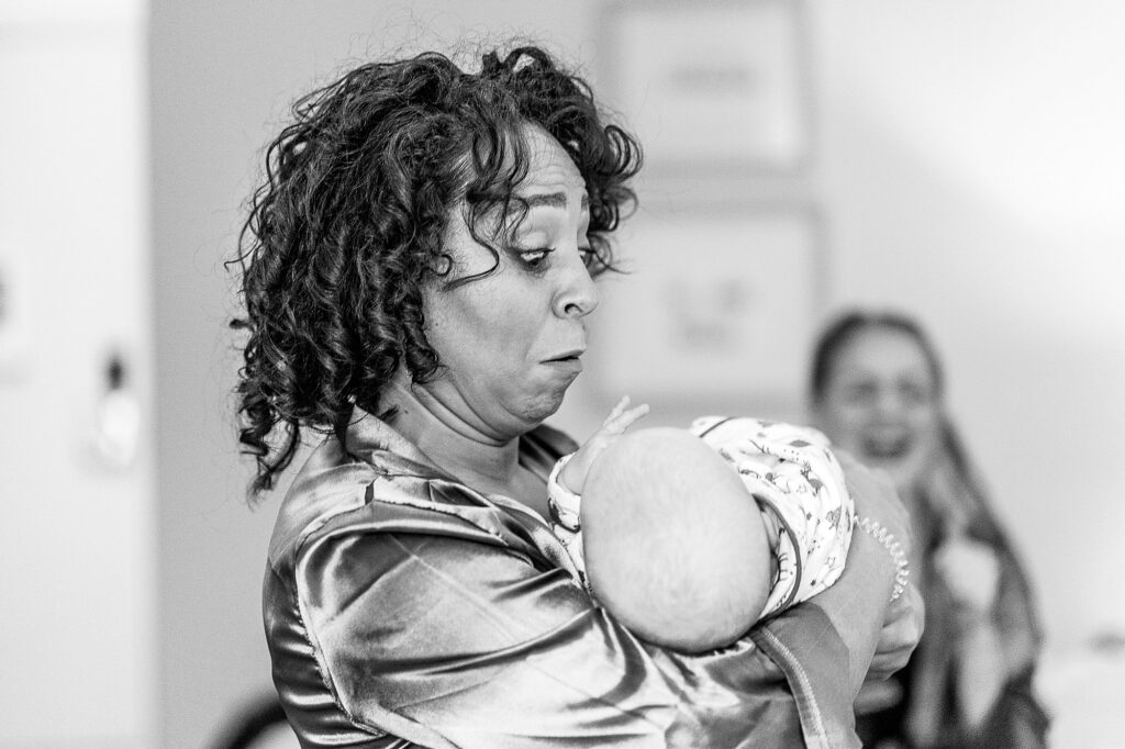 Bridesmaids looking petrified as she is handed a newborn baby // Whitchurch Hill Valley // Shropshire Wedding Venue