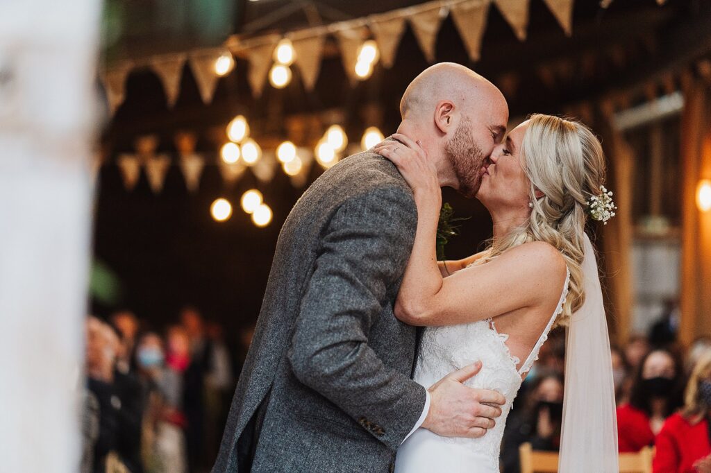 Bride and Groom kissing at the top of the aisle at Grange Barn Wedding // Cheshire Wedding Venue