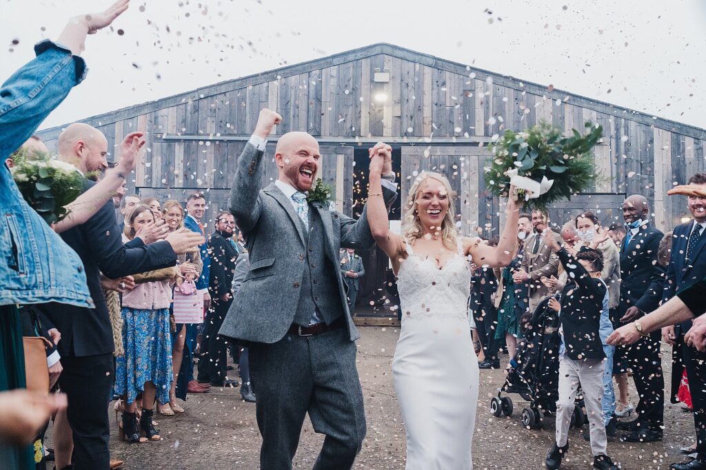 Wild confetti moment outside of Grange Barn Cheshire Wedding Venue // Charlotte Giddings Photography