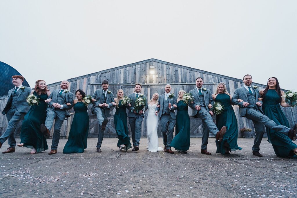 Bridal party linking arms and joking around outside of Grange Barn // Cheshire Wedding Venue