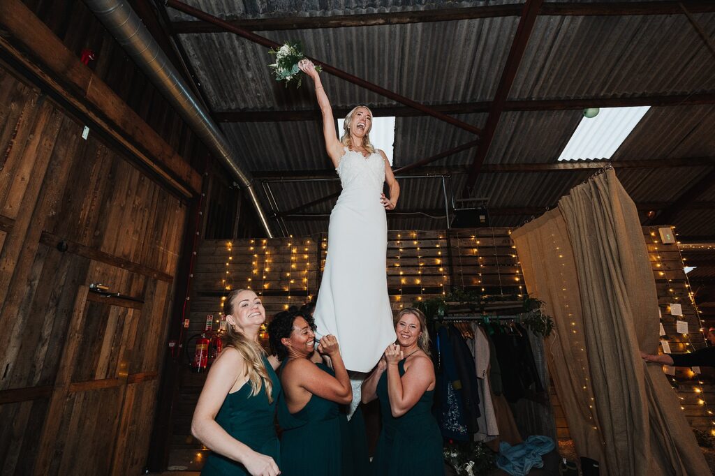 Bridesmaid reenacting a cheerleading lift with the bride // Grange Barn Wedding Photographer