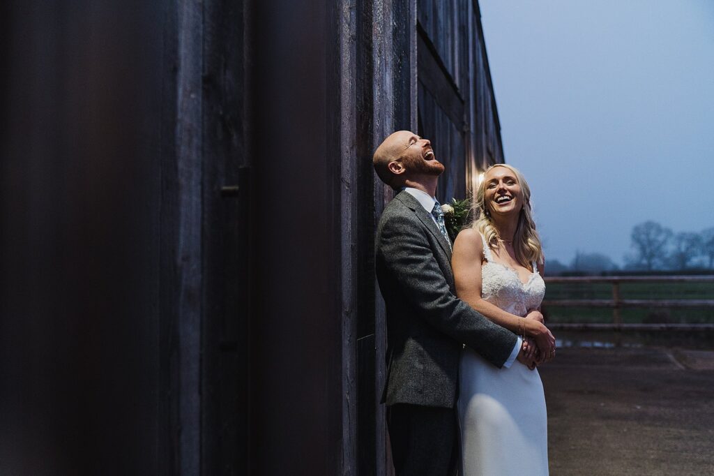Bride and Groom giggling with each other in the spotlight outside of Grange Barn before it went too dark // Charlotte Giddings Photography