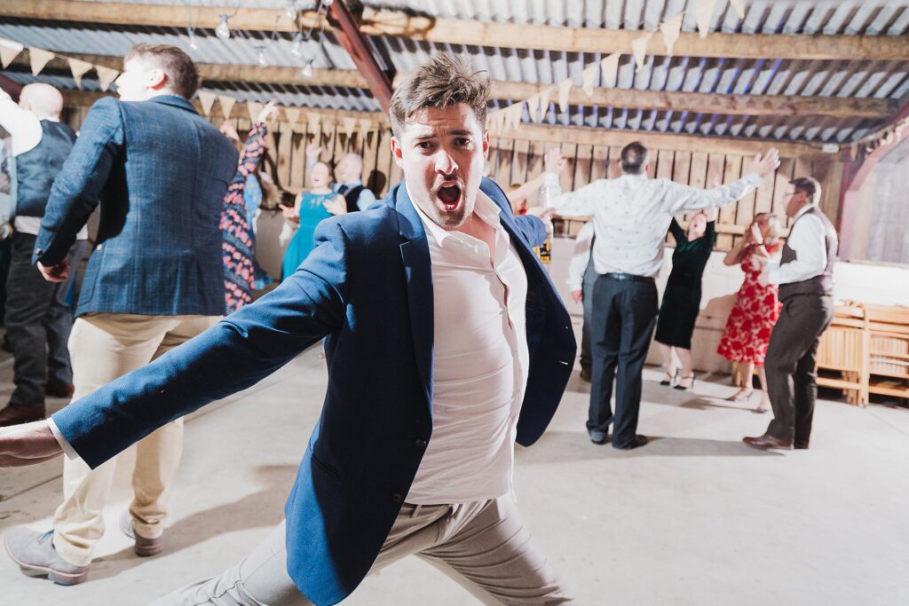 Wedding guest starting to do the splits on the dance floor at Grange Barn wedding venue