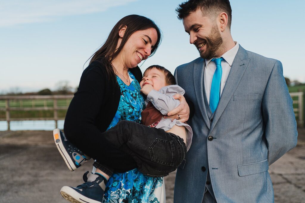 Couple outside of Grange Barn tickling their little boy and playing with him // Winter Grange Barn Wedding Cheshire