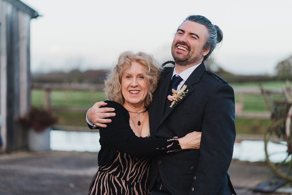 Groom cuddling his mum outside of Grange Barn Wedding Venue // Charlotte Giddings Photographer // Cheshire Wedding Photographer