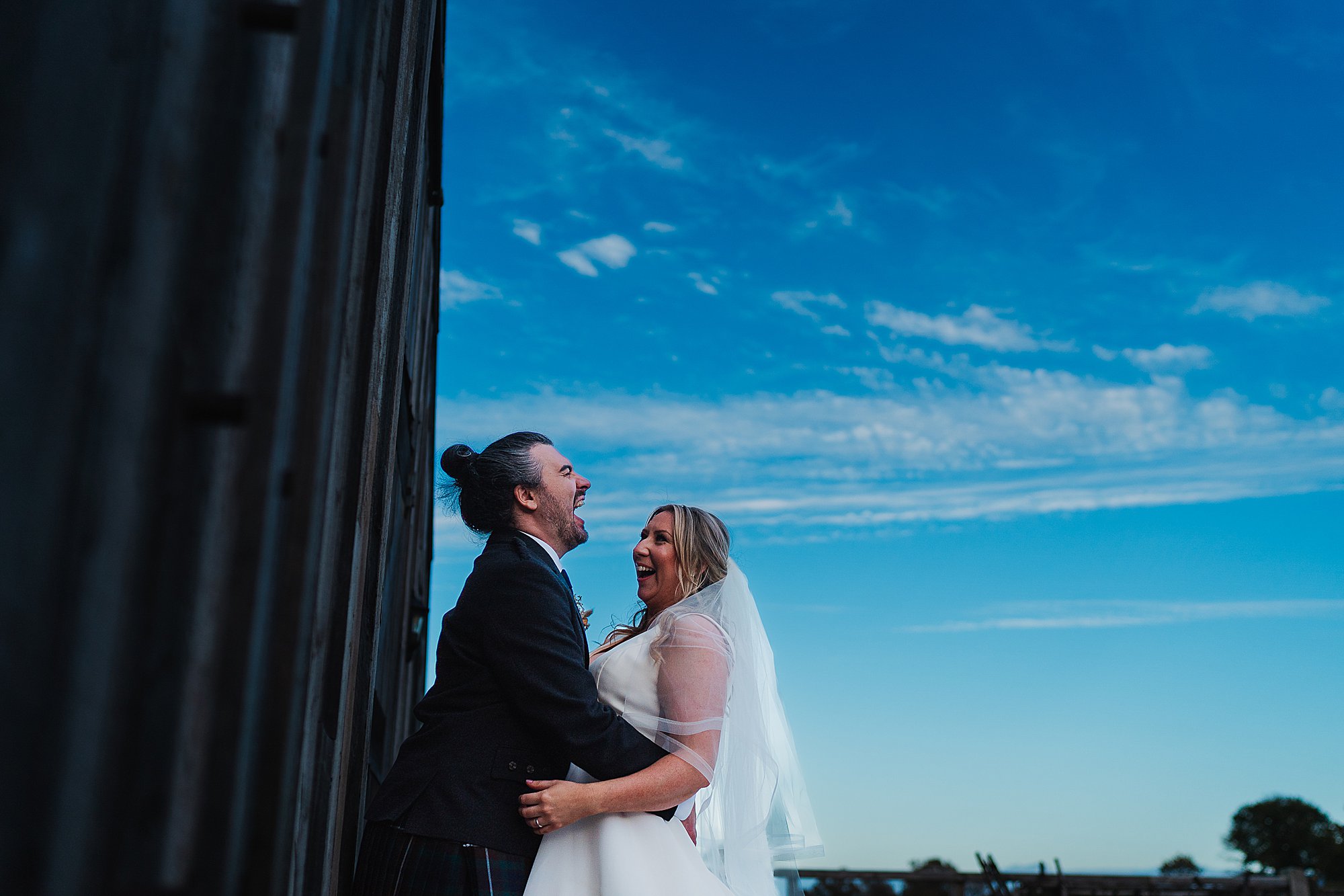 Grange Barn Wedding Photographer00048 Bride and Groom outside Grange Barn, Cheshire laughing out loud as they are having some time together