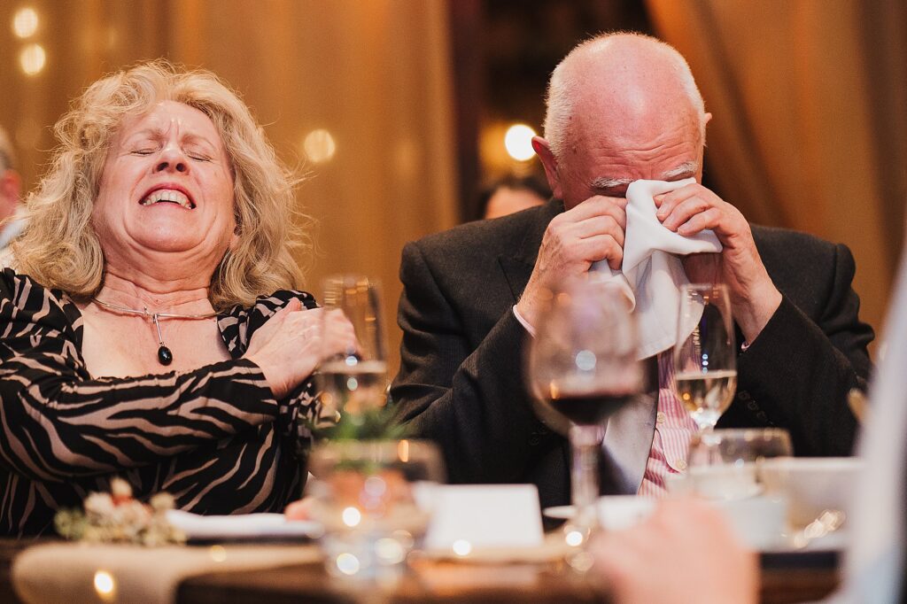 Groom's mum and dad are laughing at the speeches at Grange Barn Wedding Venue // Charlotte Giddings Photography