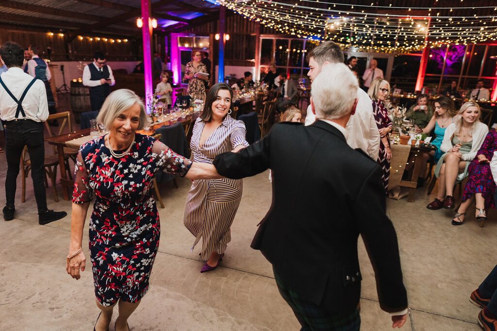 Guests dancing away to the Ceilidh Band at Grange Barn Wedding Venue // Charlotte Giddings Photography