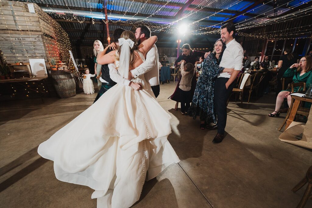 Bride cuddling some of the wedding guests as they finish a Ceilidh Band routine and getting emotional // Charlotte Giddings Photography