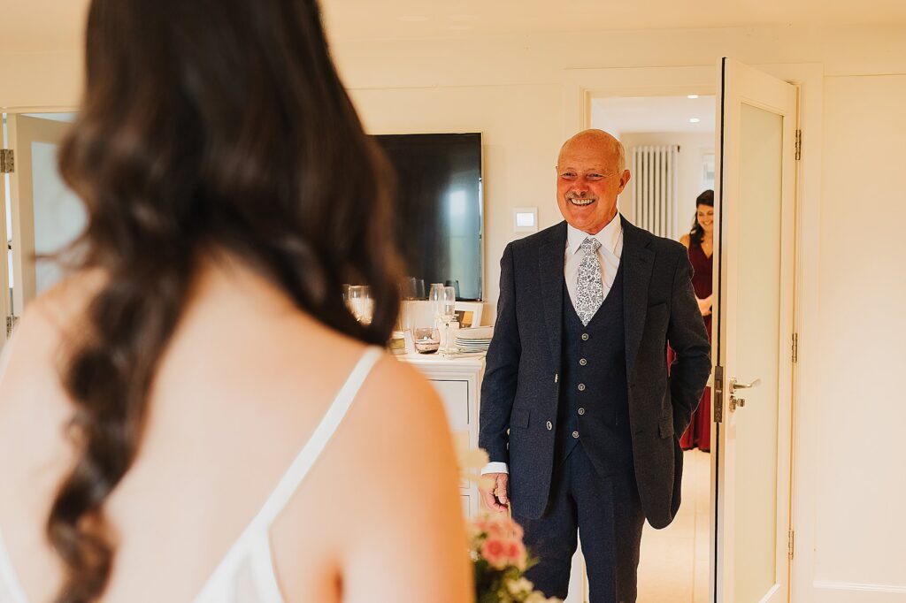 Bride's dad coming into the bedroom over the moon when he sees his daughter for the first time in her wedding dress // Hencote Wedding Photographer