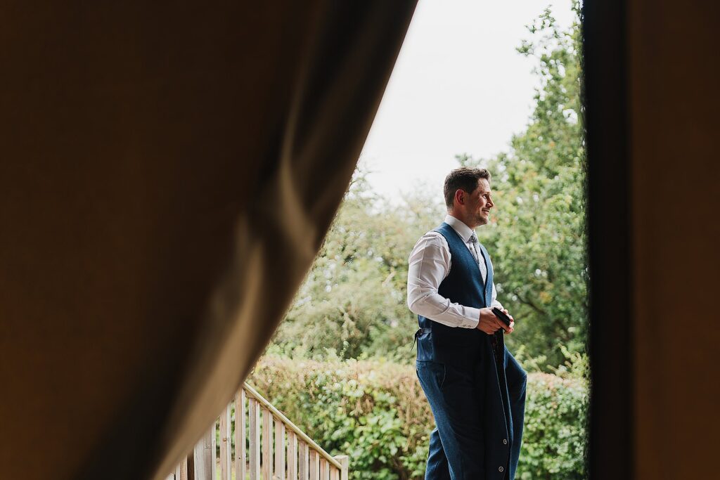 Groom waiting for a groomsman out side the safari tent at Hencote Estate // Wedding Photographer Hencote