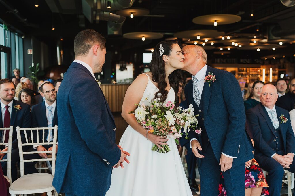 Father of the Bride kissing his daughter on the cheek at the top of the aisle as he gives her away // Shrewsbury Wedding Photographer